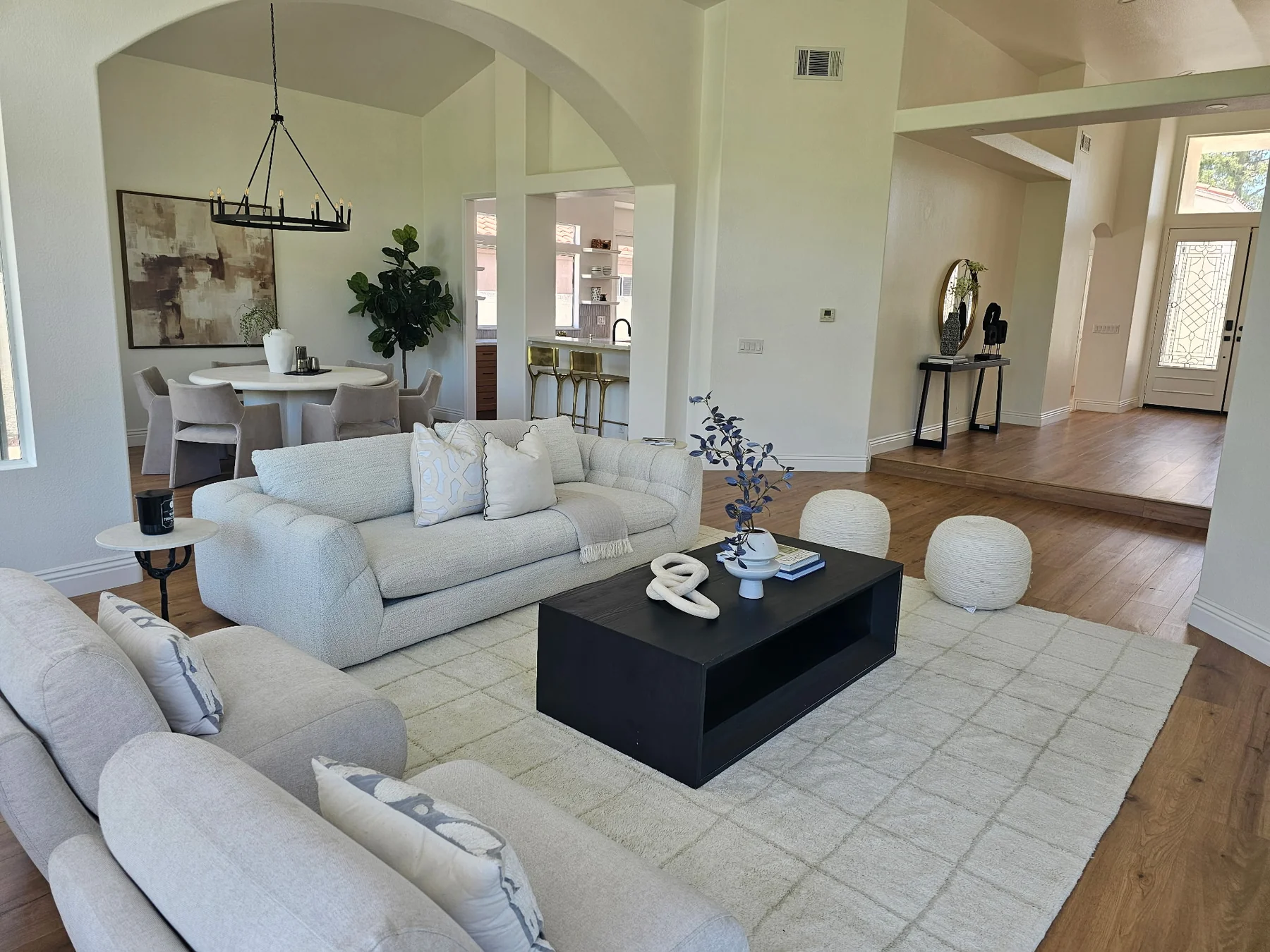 Living and dining areas connected by wide openings and continuous wood flooring.
